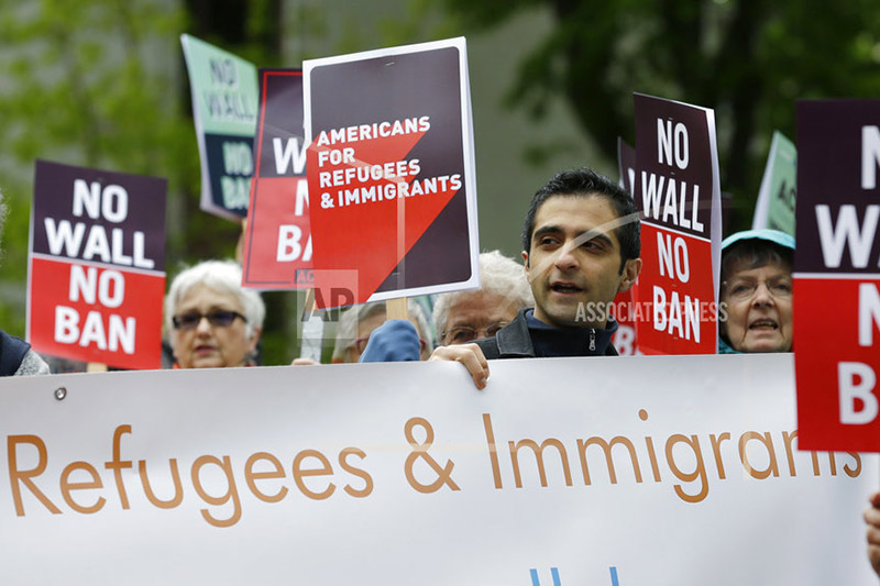 FILE--In this May 15, 2017, file photo, protesters hold signs during a demonstration against President Donald Trump's revised travel ban, Monday, May 15, 2017, outside a federal courthouse in Seattle. Photo: AP