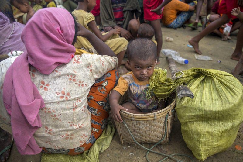 A Rohingya Muslim child sits inside a basket after the new arrivals were prevented from moving ahead towards refugee camps by Bangladesh border guard soldiers at Palong Khali, Bangladesh, on Tuesday, October 17, 2017. Photo: AP