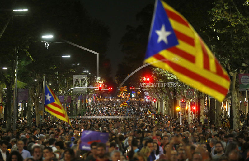 Holding candles and independence flags, people march on one of the city's main avenues to protest against the National Court's decision to imprison civil society leaders without bail, in Barcelona, Spain, Tuesday, Oct. 17, 2017. Photo: AP