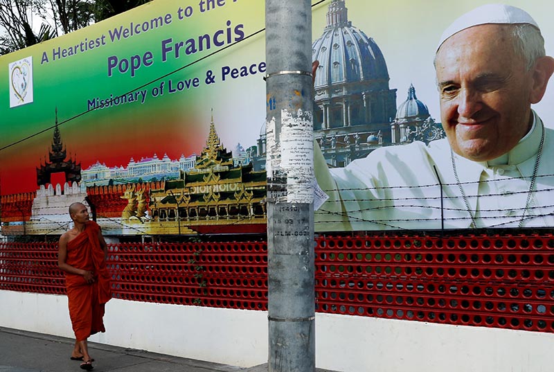 A Buddhist monk walks past a banner welcoming Pope Francis, ahead of his visit to Myanmar, in Yangon, Myanmar, on November 26, 2017. Photo: Reuters