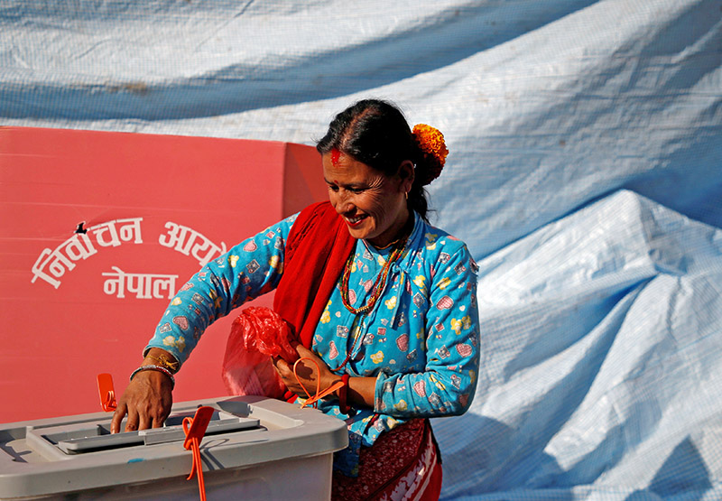 A woman smiles as she cast her vote on a ballot box during the parliamentary and provincial elections in Sindhupalchok District, Nepal November 26, 2017. Photo: Reuters