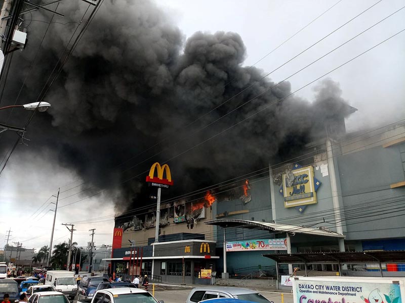 Smoke billows from a shopping mall on fire in Davao City, the Philippines, in this December 23, 2017. Photo: AP