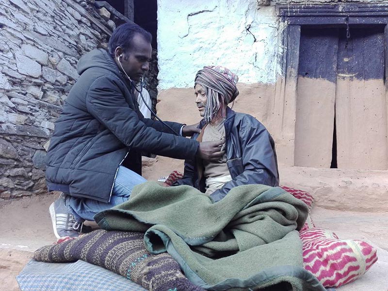 FILE - Dr Bijay Kumar Sah of District Health Office, Bajura, checks a viral fever patient in Swamikartik Rural Municipality-5, of Bajura district, on Monday, December 18, 2017. Photo: Prakash Singh