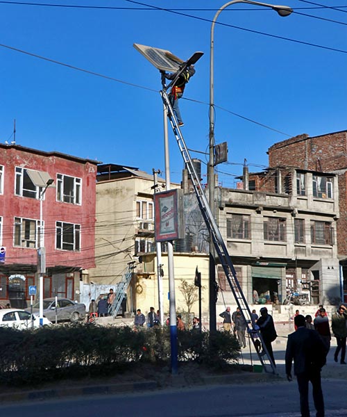Workers cleaning the solar panels installed in the street lamps beside Maitighar Road of Kathmandu district, on Thursday, December 14, 2017. Photo: RSS