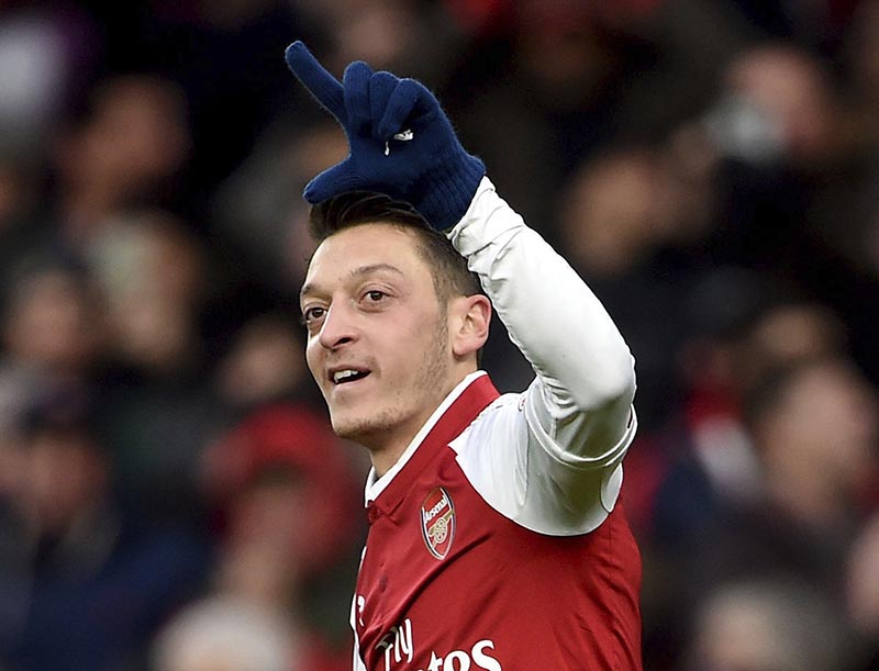 Arsenal's Mesut Ozil celebrates scoring his side's first goal of the game, during the English Premier League soccer match between Arsenal and Newcastle United, at the Emirates Stadium, in London,  on Saturday, December 16, 2017. Photo: Joe Giddens/PA via AP