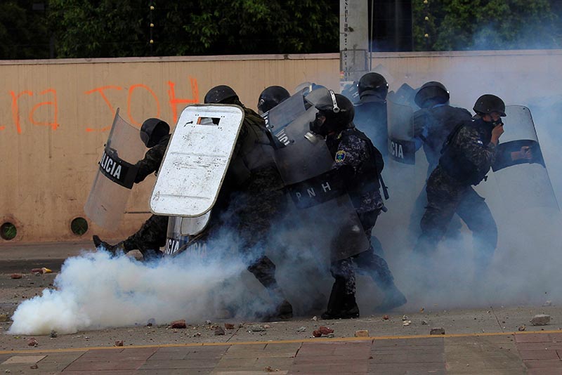 Military policemen react to a gas canister thrown back by a supporter of Salvador Nasralla, presidential candidate for the Opposition Alliance Against the Dictatorship, during a protest caused by the delayed vote count for the presidential election in Tegucigalpa, Honduras, on November 30, 2017. Photo: Reuters