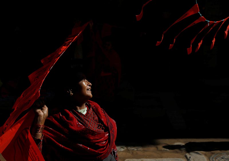 Light illuminates a woman as she hangs the election symbol of Nepal Workers Peasants Party along the streets to prepare for the victory rally after their candidate won in a Constituency from Bhaktapur, Nepal, on December 12, 2017. Photo: Reuters