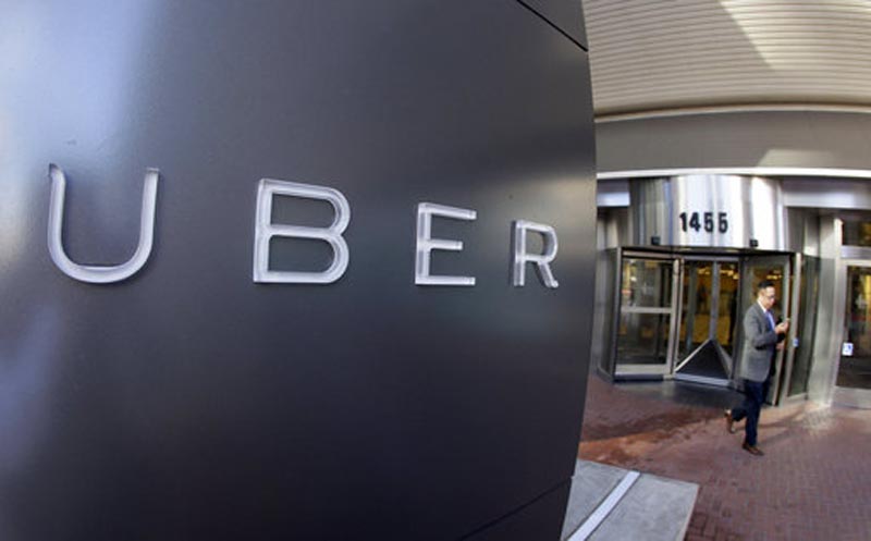 FILE - In this Dec. 16, 2014, file photo a man leaves the headquarters of Uber in San Francisco. Ride-hailing service Uber suffered a new blow Wednesday, Dec. 20, 2017 as the European Union's top court ruled that it should be regulated like a taxi company and not a technology service, a decision that could change the way it functions across the continent. (AP Photo/Eric Risberg, File)