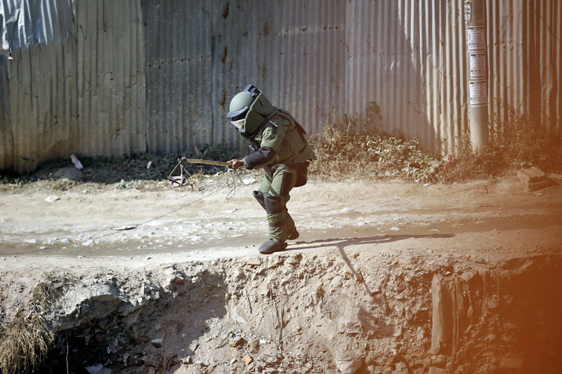 A Nepal Army bomb disposal team member prepares to detonate a pressure cooker bomb, a few hours ahead of the second phase of parliamentary and provincial elections in Kathmandu, on Wednesday, December 6, 2017. Improvised explosive devices had been planted in many areas during the election period. Photo: Skanda Gautam