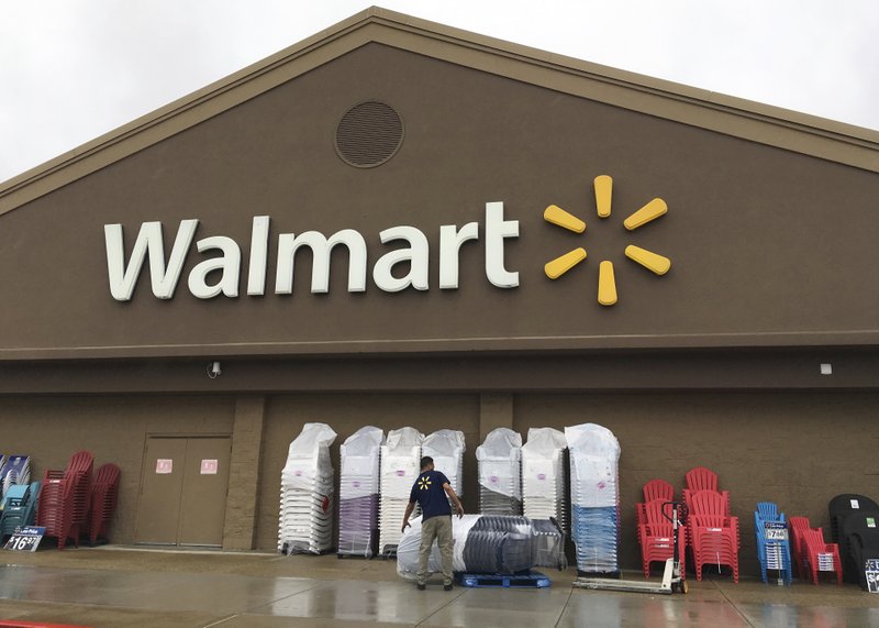 a worker stacks merchandise outside a Walmart in Salem, N.H. Walmart is boosting its starting salary for U.S. workers to $11 an hour, giving a one-time $1,000 cash bonus to eligible employees and expanding its maternity and parental leave benefits. The retailer said Thursday, Jan. 11, 2018, changes to its compensation and benefits policy will impact more than a million hourly workers in the U.S., with the wage increase effective next month.