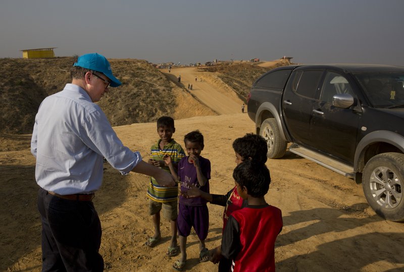 UNICEF Deputy Executive Director Justin Forsyth, left, shares biscuits with Rohingya refugee children as he leaves Balukhali refugee camp 50 kilometres (32 miles) from, Coxu2019s Bazar, Bangladesh Wednesday, Jan. 24, 2018. Forsyth is on a two day visit to Coxu2019s Bazar to see, first-hand, the devastating humanitarian situation of the Rohingya refugees. 