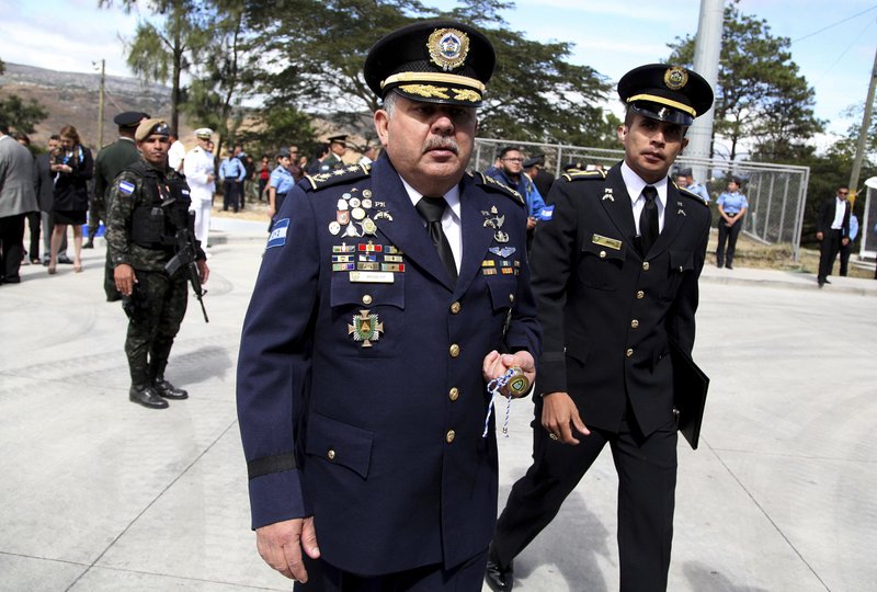 , Hondurasu2019 new national Police Chief Jose David Aguilar Moran, center, leaves after a ceremony that transferred command to him in Tegucigalpa, Honduras. When Aguilar took over as Hondurasu2019 new national police chief, he promised to continue reforming a law enforcement agency stained by corruption and complicity with drug cartels, but a confidential government security report obtained by the Associated Press says Aguilar himself helped a cartel leader pull off the delivery of nearly a ton of cocaine in 2013. 