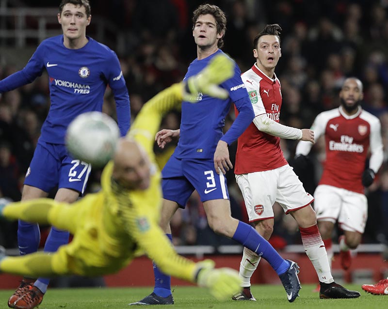 Arsenal's Mesut Ozil (right), shoots during the English League Cup semifinal second leg soccer match between Chelsea and Arsenal at the Emirates stadium in London, on Wednesday, January 24, 2018. Photo: AP