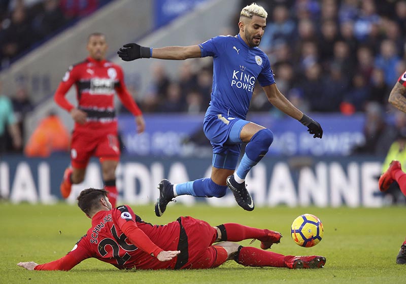 Leicester City's Riyad Mahrez (right), and Huddersfield Town's Christopher Schindler battle for the ball during their English Premier League soccer match at the King Power Stadium in Leicester, England, on Monday January 1, 2018. Photo: Nigel French/PA via AP