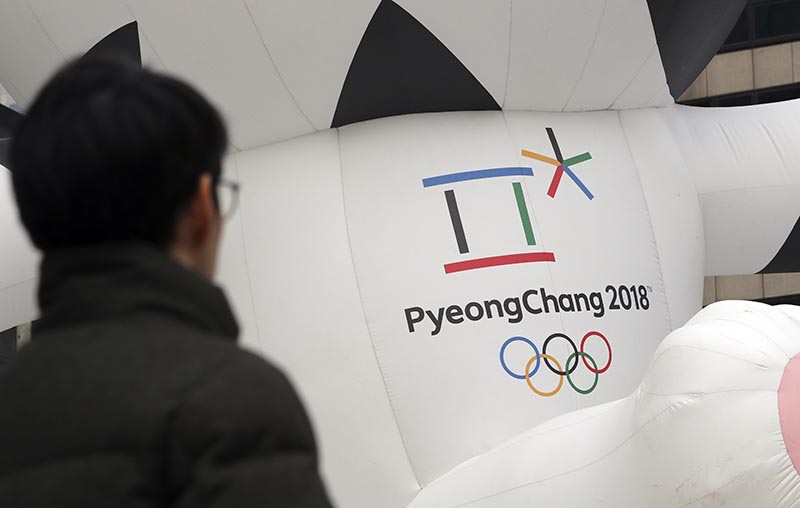 A man walks by the official emblem of the 2018 Pyeongchang Olympic Winter Games, in downtown Seoul, South Korea, on December 29, 2017. Photo: AP