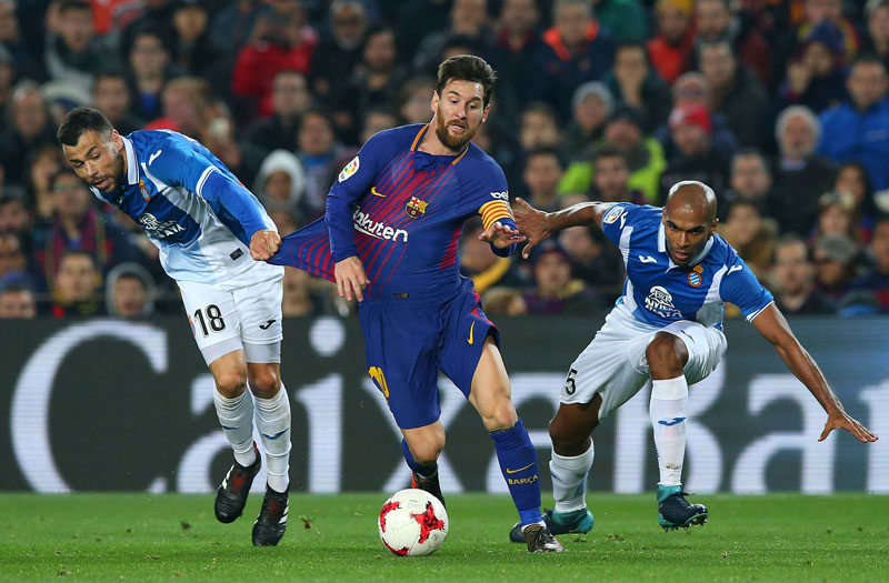 Barcelona's Lionel Messi in action with Espanyol's Naldo and Javi Fuego. Photo: Reuters