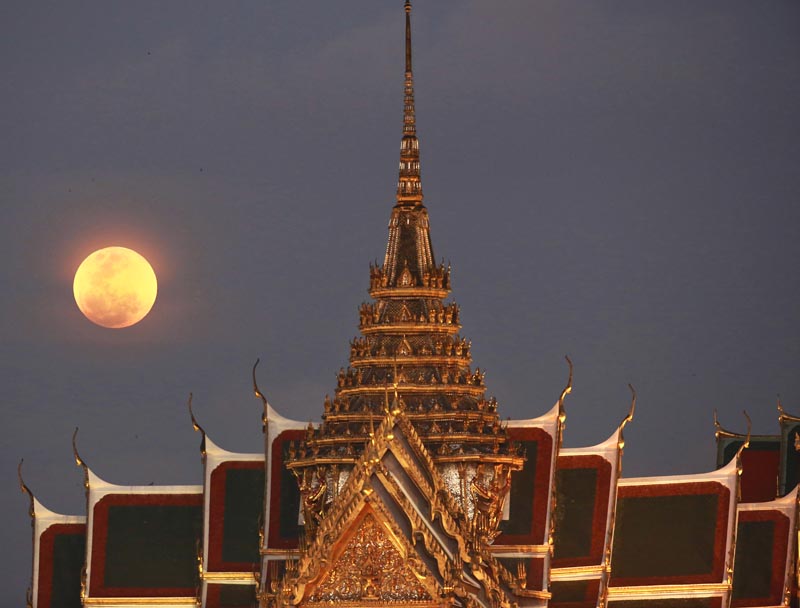 A full moon rises beside the Grand Palace in Bangkok, Thailand, Wednesday, January 31, 2018. The moon is putting on a rare cosmic show. It's the first time in 35 years a blue moon has synced up with a supermoon and a total lunar eclipse. Photo: AP
