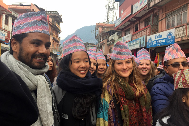 Locals along with foreigners pose for a portrait after wearing Nepali topi on the occasion of National Topi Day in Besishahar of Lamjung district, on Monday, January 01, 2018. Photo: RSS