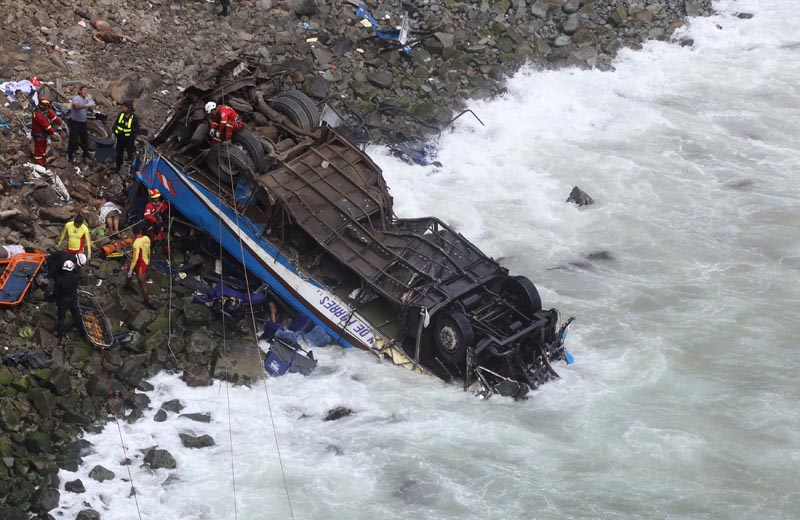Rescue workers and police work at the scene after a bus crashed with a truck and careened off a cliff along a sharply curving highway north of Lima, Peru, January 2, 2018. Photo: Reuters
