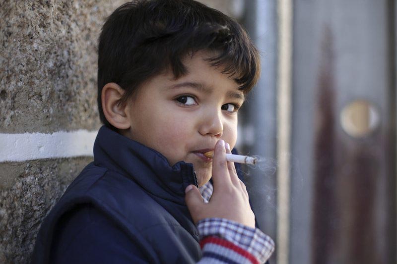 File - Fernando, 6-years-old, smokes a cigarette in the village of Vale de Salgueiro, northern Portugal, during the local Kingsu0092 Feast on  Saturday, Jan. 6, 2018. Photo: AP