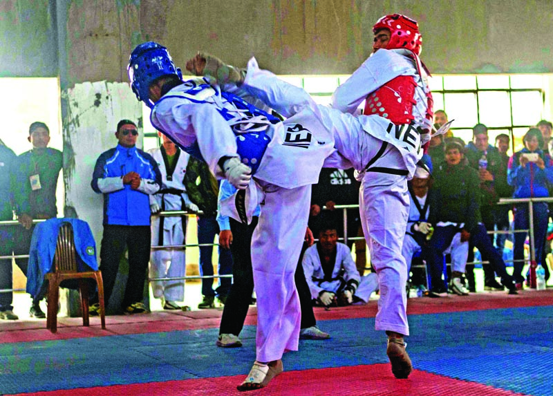 TACu0092s Gyanendra Hamal (right) fights against NPCu0092s Bikrant Dangol during the14th National Taekwondo Tournament in Lalitpur on Friday, Jan 19, 2018. Photo: THT