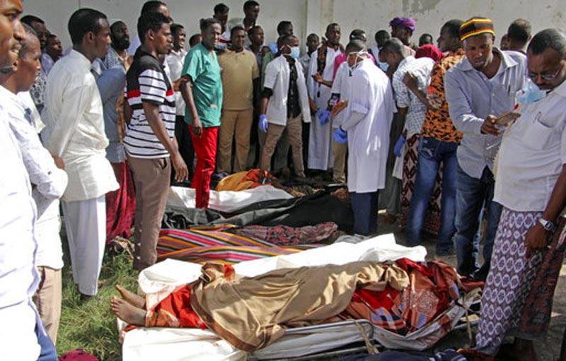 FILE - In this Friday, Aug. 25, 2017 file photo, Somalis observe bodies which were brought to and displayed in the capital Mogadishu, Somalia, following a raid by foreign and Somali forces on a farm in Bariire village in southern Somalia. A spokesman for U.S. Africa Command said Wednesday, Dec. 13, 2017 that its head Marine Gen. Thomas Waldhauser has asked the Naval Criminal Investigative Service to look into whether civilians were killed during the raid by Somali troops supported by U.S. special operations forces. (AP Photo/Farah Abdi Warsameh, File)