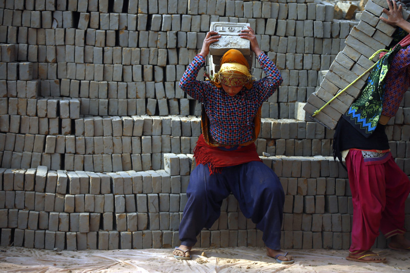 A woman stack bricks at a brick kiln in Bhaktapur, on Thursday, January 11, 2018. Photo: Skanda Gautam