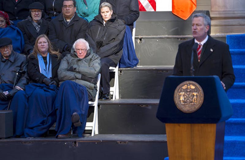 Senator Bernie Sanders, I-Vt., and his wife Jane O'Meara Sanders, center left, listen to New York Mayor Bill de Blasio speak after he was sworn in by Sen. Sanders for a second term as mayor at City Hall in a frigid New York, Monday, Jan. 1, 2018.