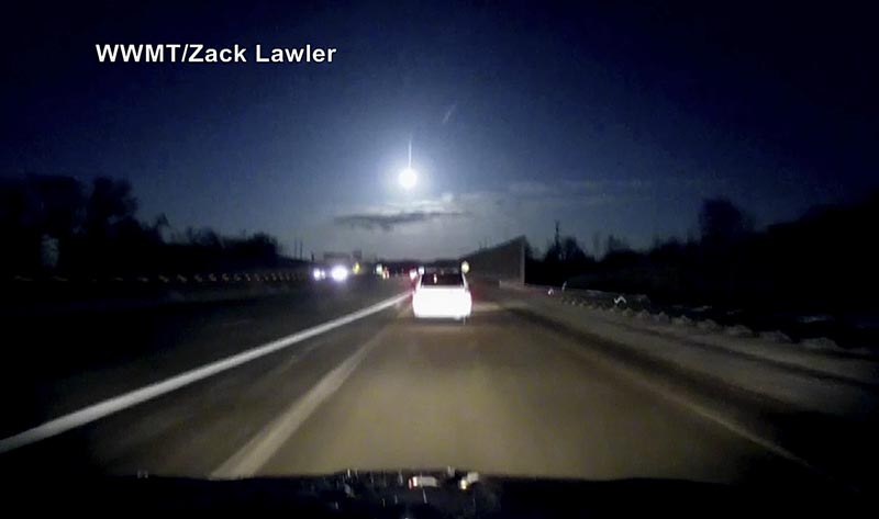 In this late Tuesday, January 16, 2018, image made from dashcam video, a brightly lit object falls from the sky above a highway in the southern Michigan skyline. Photo: Zack Lawler/AP