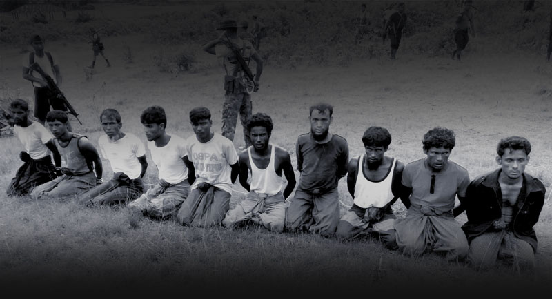 EXECUTION: This photo was taken on the day the 10 Rohingya men were killed. Paramilitary police officer Aung Min, left, stands guard behind them. The picture was obtained from a Buddhist village elder, and authenticated by witnesses.