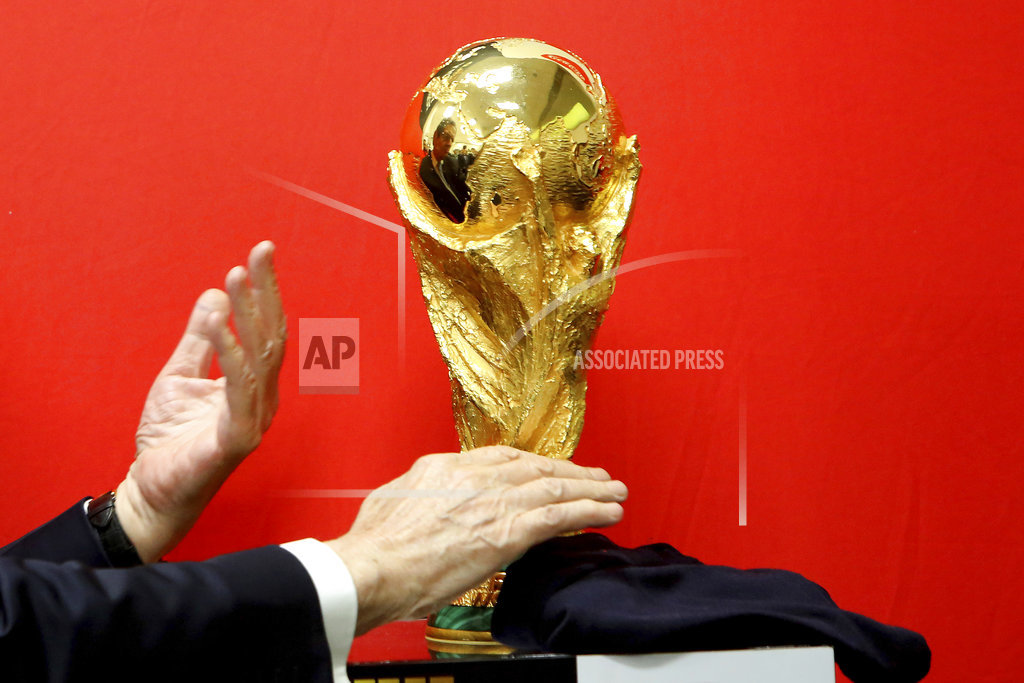 Cyprus' President Nicos Anastasiades unveils the FIFA World Cup trophy during its world tour at a stop at the international airport in the southern city of Larnaca, Cyprus, on Friday, Feb. 16, 2018. The trophy will visit some 50 countries as it make its journey round the world to Moscow for the start of the World Cup 2018 in Russia. (AP Photo/Petros Karadjias)