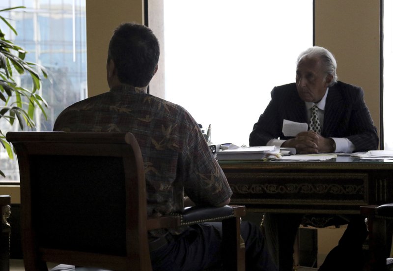 Honolulu attorney Michael Green, right, sits with his client, the former Hawaii Emergency Management Agency employee who sent a false missile alert to residents and visitors in Hawaii, left, during an interview with reporters, Friday, Feb. 2, 2018 in Honolulu. The ex-state employee says heu2019s devastated about causing panic, but he believed it was a real attack at the time. The man in his 50s spoke to reporters Friday on the condition he not be identified because he fears for his safety after receiving threats. (AP Photo/Jennifer Sinco Kell