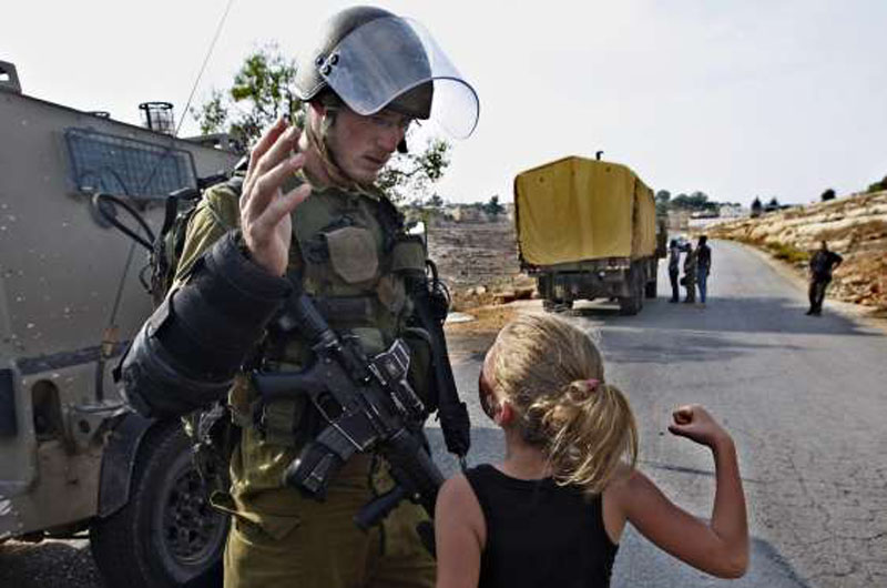 FILE-In this November 2, 2012 file photo, then 12-year-old Ahed Tamimi tries to punch an Israeli soldier during a protest in the West Bank village of Nabi Saleh. Tamimi is to go on trial Tuesday. Photo: AP