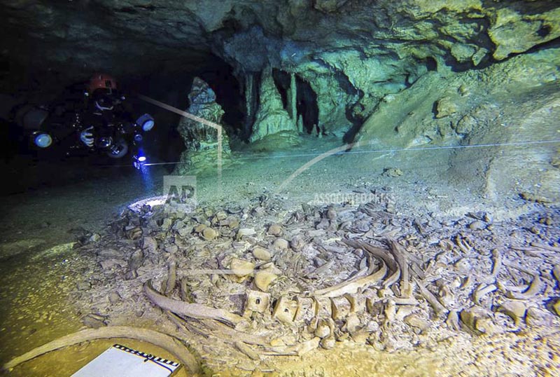 This undated photo released by Mexico's National Anthropology and History Institute (INAH) shows divers from the Great Mayan Aquifer project, left, exploring the Sac Actun underwater cave system, where Mayan and Pleistocene bones and cultural artifacts have been found submerged, near Tulum, Mexico. Photo: AP