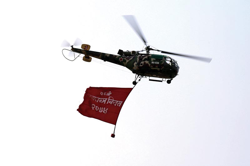 FILE - A Nepali Army helicopter hoisting a flag of National Democracy Day