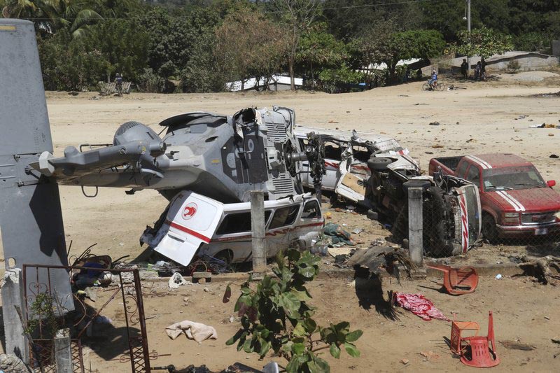 A downed helicopter lays in its side on top of a van, in Santiago Jimitepec, Oaxaca state, Mexico, on Saturday, Feb. 17, 2018. Photo: AP
