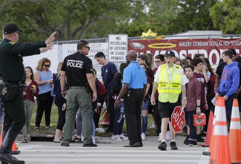 Students wait to cross the street after their first day back at Marjory Stoneman Douglas High School in Parkland, Wednesday, Febrary 28, 2018. Photo: AP