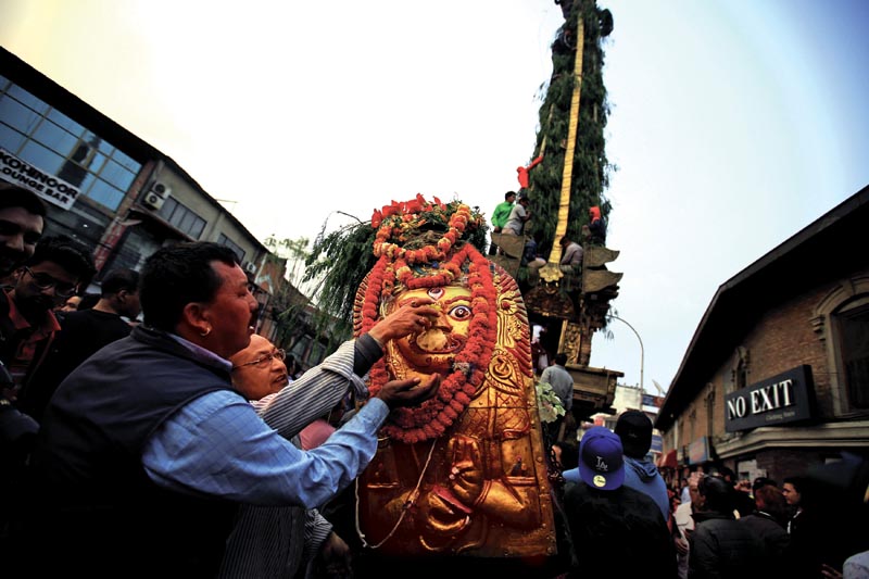 Devotees offer prayers on an idol of a deity placed in front of a chariot of Seto Machindranath during the chariot festival in Kathmandu, Nepal on Sunday, March 25, 2018. Photo: THT