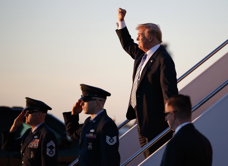 President Donald Trump gestures to people cheering him across the tarmac as he, arrives on Air Force One with first lady Melania Trump and their son Barron Trump at Palm Beach International Airport, in West Palm Beach, Florida, on Friday, March 23, 2018. Photo: AP