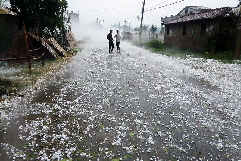 Two men stand on the road to see the hailstones fallen in Pipara area of Durga Bhagawati Rural Municipality, in Rautahat district, on Friday, March 30, 2018. Photo: Prabhat Kumar Jha