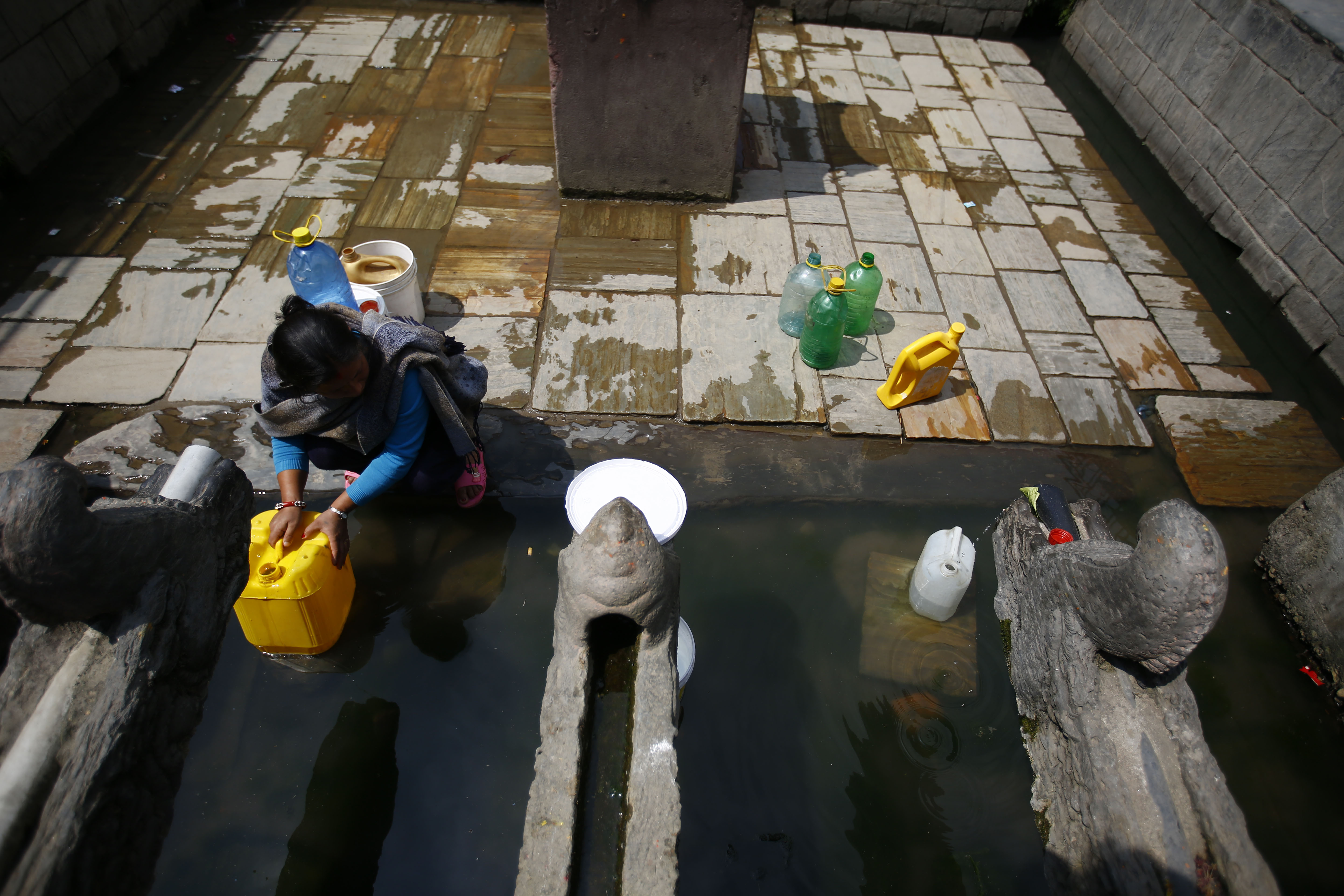 A woman collects drinking water from a traditional water spout on World Day for Water in Lalitpur, on Thursday, March 22, 2018. Photo: Skanda Gautam