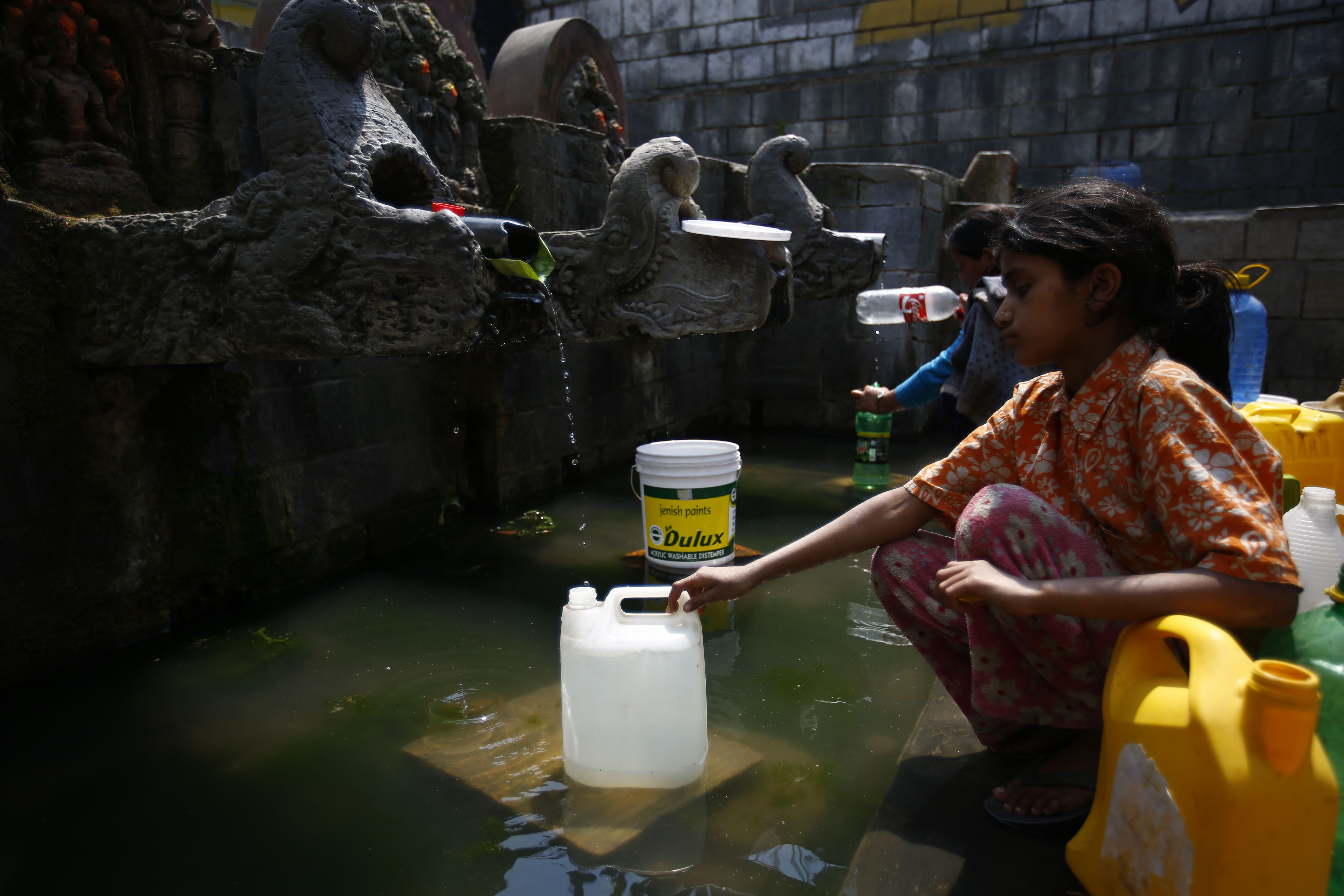 A girl collects drinking water from a traditional water spout on World Water Day in Lalitpur, on Thursday, March 22, 2018. Photo: Skanda Gautam