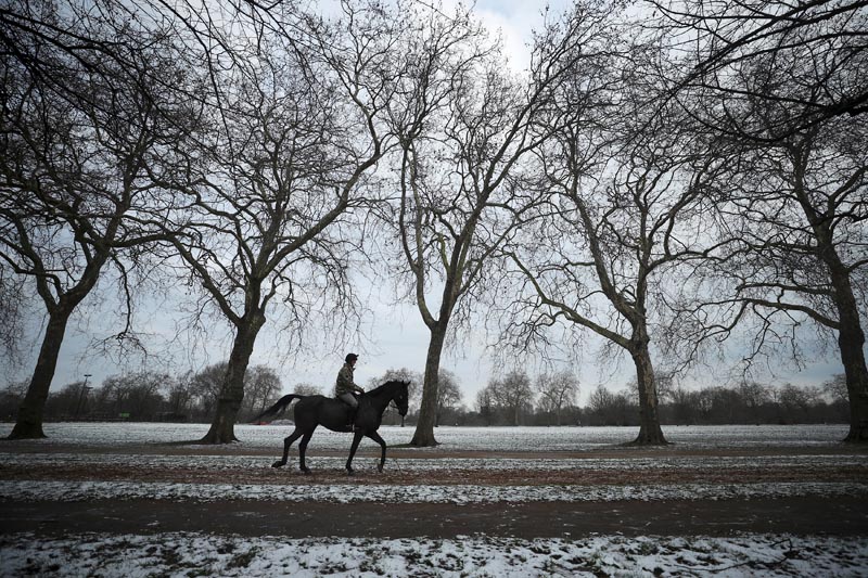A man rides a horse through Hyde Park after a light snow fall in London, Britain, March 19, 2018. Photo: Reuters