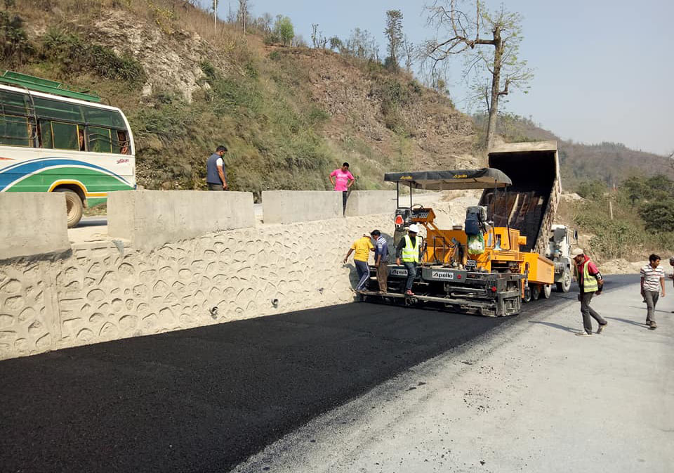 Workers black top a road section of Narayangadh-Muglin roadway on Monday, March 19, 2018.