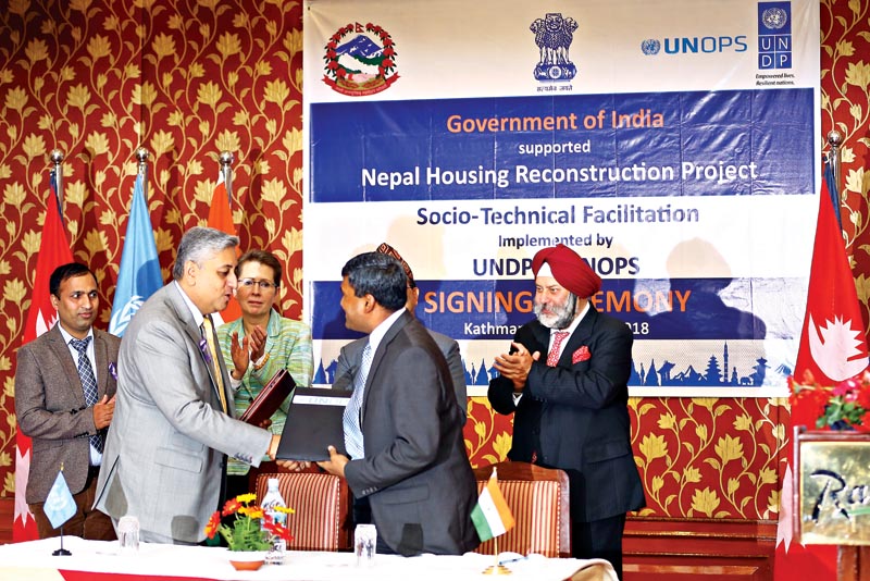 Ajay Kumar, deputy chief of mission, Embassy of India, signing and exchanging a partnership agreement to expedite the reconstruction process in Nepal with Renaud Meyer, country director of UNDP, Nepal (left) and Sanjay Mathur, regional director of UNOPS Asia Region, in Kathmandu, on Thursday. Behind them, UN Resident Coordinator Valerie Julliand, NRA CEO Yubaraj Bhusal and Indian Ambassador to Nepal Manjeev Singh Puri can be seen overseeing the signing ceremony. Photo : THT Print 