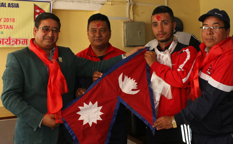 NOC President Jeevan Ram Shrestha (left) handing over national flag to handball team members during a rfarewell programme on Thursday. Photo: THT