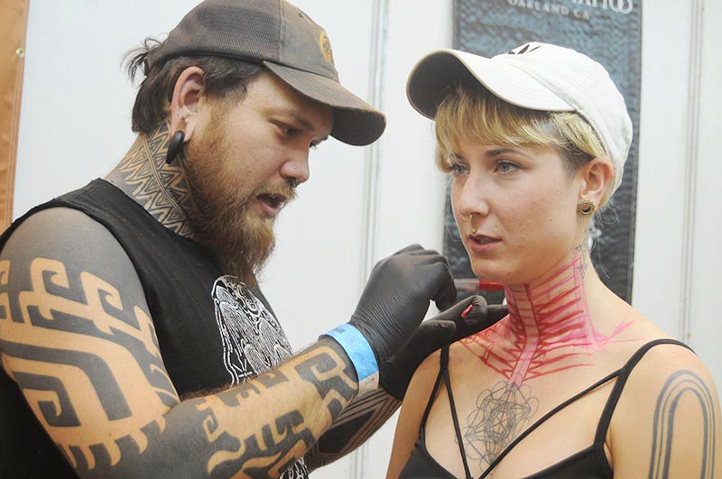 A foreign woman getting tattoo on her neck at the 8th International Napal Tattoo Convention, at Heritage Garden, in Sanepa, Lalitpur, on Friday, April 7, 2018. Photo: Balkrishna Thapa Chhetri/THT
