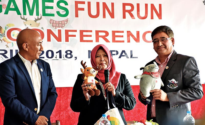 Asian Games Organising Committee's Media and Public Relations Vice-director Ratna Irsana shows a mascot as NOC President Jeevan Ram Shrestha and Secretary General Lama Tendi Sherpa (left) look on during a press meet in Lalitpur on Monday. Photo: THT