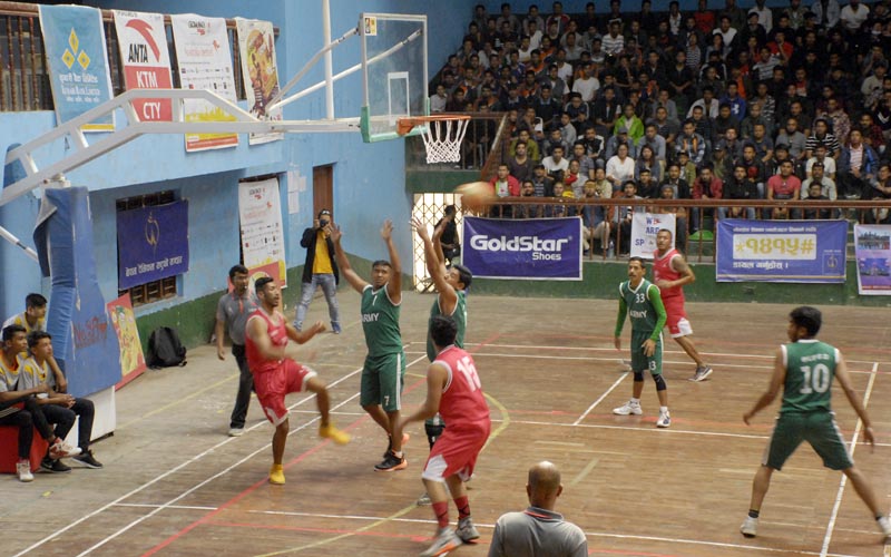Action in the match between Golden Gate (red) and TAC during the Kwiku0092s Basketball League final at the NSC covered hall in Kathmandu on Saturday, March 31, 2018. Photo: THT