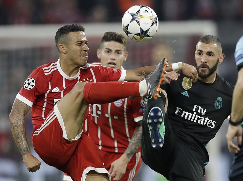 Bayern's Thiago (left), and Real Madrid's Karim Benzema challenge for the ball during the semifinal first leg soccer match between FC Bayern Munich and Real Madrid at the Allianz Arena stadium in Munich, Germany, on Wednesday, April 25, 2018. Photo: AP